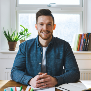 man aan bureau schoolcoach